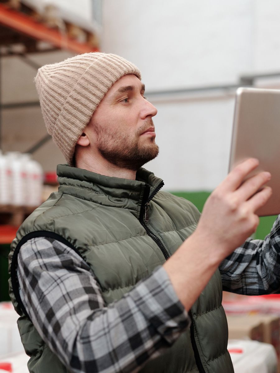 Warehouse staff member checking stock against a tablet