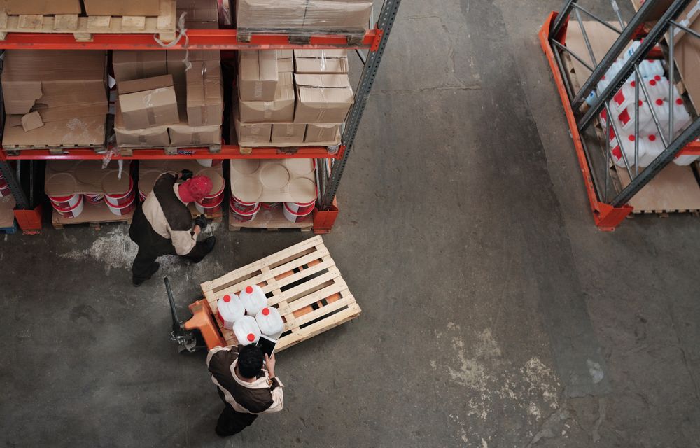 Staff organising pallets across a distribution warehouse