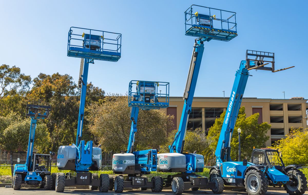 Row of self-propelled boom lifts lined up in a hire yard