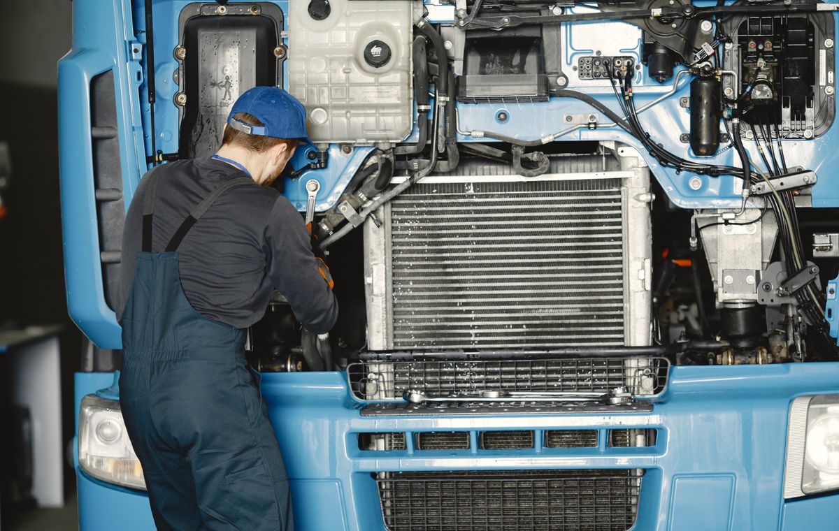 Mechanic working on a truck engine in a service workshop